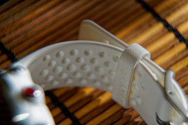 Ahşap masa üzerinde beyaz renkte spor izlemek, koşma ve fitness eğitimi için akıllı saat.