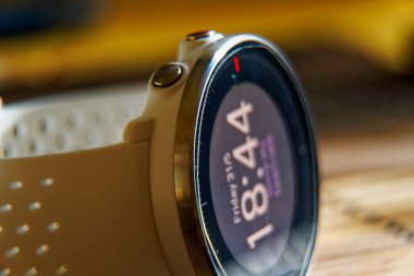 Ahşap masa üzerinde beyaz renkte spor izlemek, koşma ve fitness eğitimi için akıllı saat.