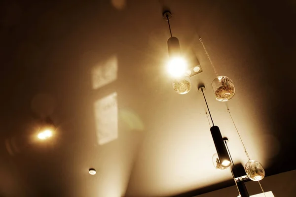 Декоративний дизайн освітлення, інтер'єр кафе, лампа з лампою, що висить у кафе. Декоративний індустріальний інтер'єр Стиль лофт в ресторані - Панорамний знімок . — стокове фото