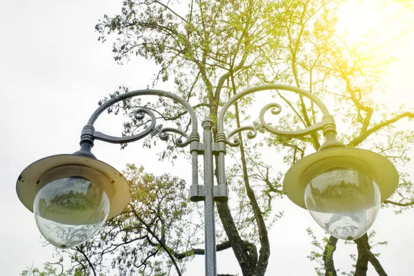 Lanternas redondas transparentes em um fundo natural desfocado. Um close-up de um vidro esférico luzes de rua plafond — Fotografia de Stock