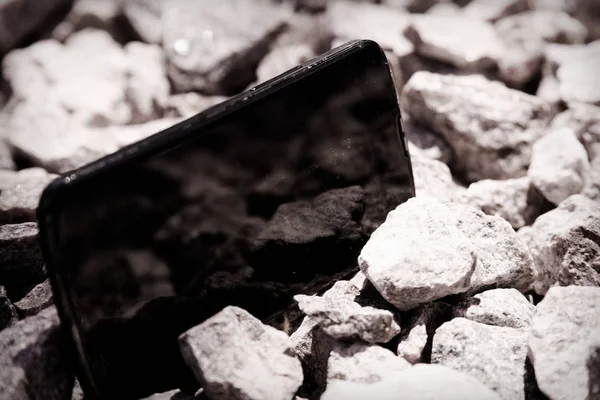 Broken cellphone abandoned and lost among the gravel