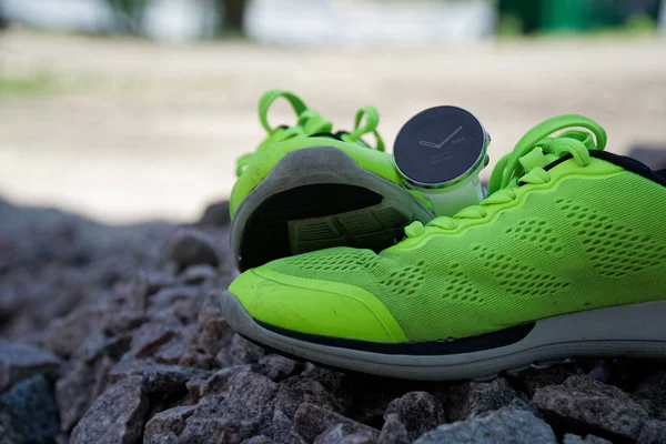 Reloj deportivo para crossfit y triatlón en las zapatillas de running verdes. Reloj inteligente para el seguimiento de la actividad diaria y el entrenamiento de fuerza . —  Fotos de Stock