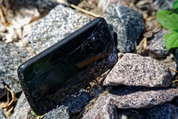 Broken cellphone abandoned and lost among the gravel