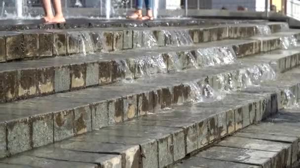 Gambe scalze giocare con getti d'acqua fontana. La gente in città gioca con l'acqua nelle fontane, felice e spensierata, concetto di libertà e felicità nell'infanzia, a partire dall'estate e dalle città turistiche. . — Video Stock