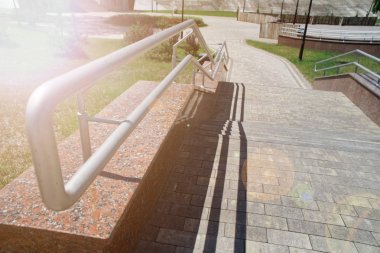 Metal korkuluklar yolu geçerken, yakın çekim, gölgeler. Güneş Işın ışıkları