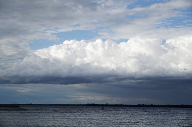 Fırtına bulutu ve deniz feneri. Dramatik cloudscape doku. Yağmurdan önce karanlık şiddetli fırtına bulutları. Bulutlu yağmurlu kötü hava. Fırtına uyarısı. Kümülonimbus doğal mavi arka plan