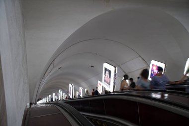Kiev, Ukrayna, 6 Temmuz 2019: Kiev metro istasyonunda yürüyen merdivenle seyahat eden yolcular, Ukrayna