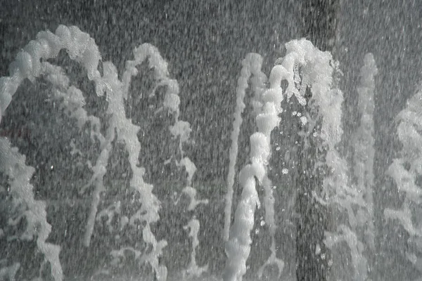 Fuente en la luz del sol. Las fuentes que brotan agua con gas de la tubería en el parque —  Fotos de Stock