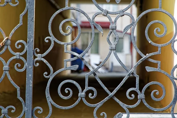 Vieux patio paisible derrière une clôture en acier, mise au point douce, fond bleu — Photo