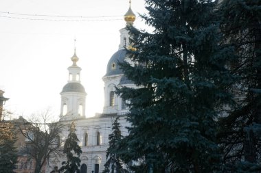 Ortodoks Kilisesi 'nin bir parçası, önü güneşli, arkası aydınlık. Güneş ışınları kilisenin kubbesini delip geçiyor. Kilisenin haçı mavi gökyüzüne karşı