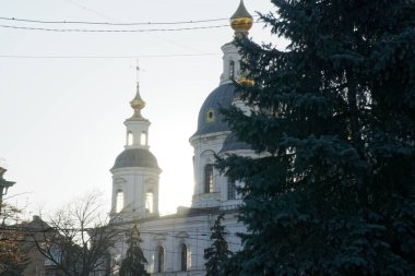 Ortodoks Kilisesi 'nin bir parçası, önü güneşli, arkası aydınlık. Güneş ışınları kilisenin kubbesini delip geçiyor. Kilisenin haçı mavi gökyüzüne karşı