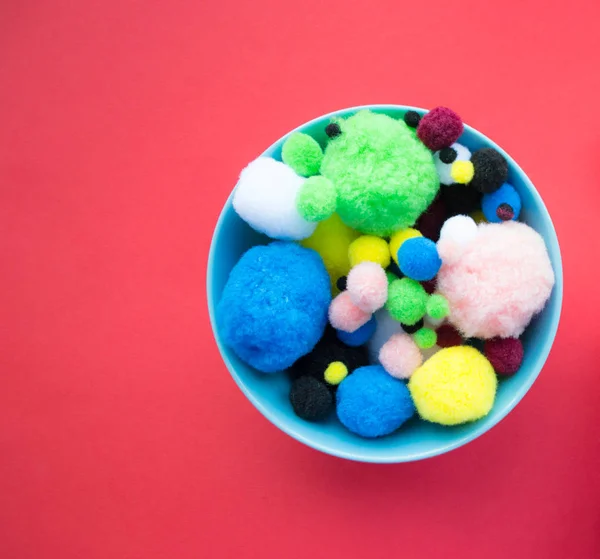Blue bowl of fluffy ball on red background — Stock Photo, Image