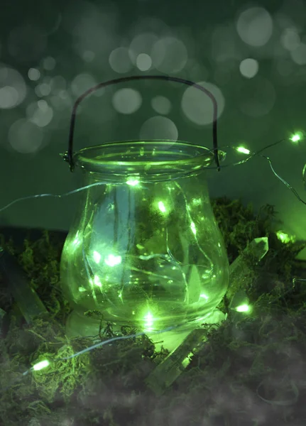 Magic cauldron on green background with moss and firefly and fog and smoke and bokeh