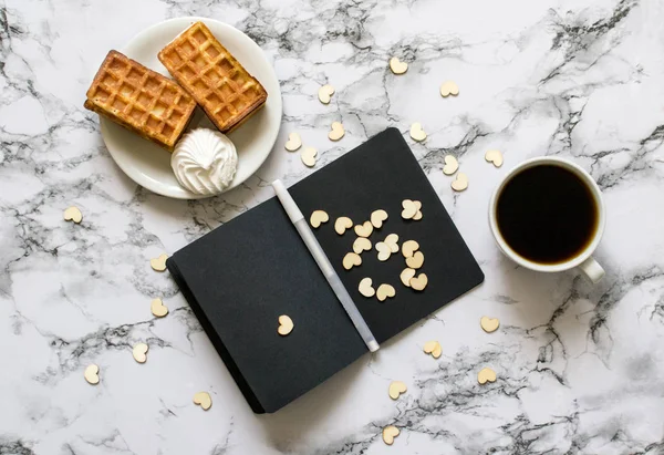 Notitieboekje met zwarte lakens op een marmeren achtergrond en koffie — Stockfoto