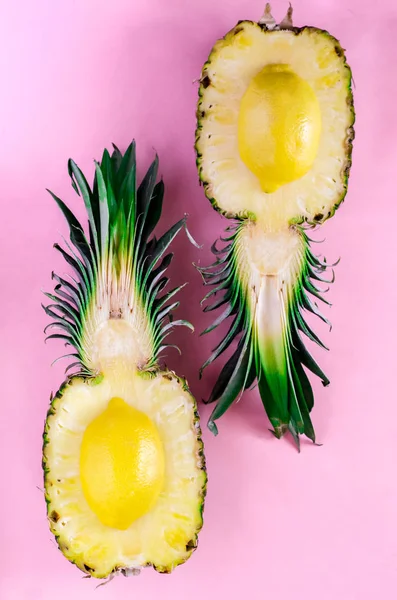 Vers gesneden ananas met ondersteboven citroenen op roze achtergrond — Stockfoto