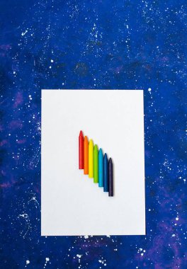 Galaksi mavisi arkaplanda beyaz kağıt ve çok renkli pastel boya.