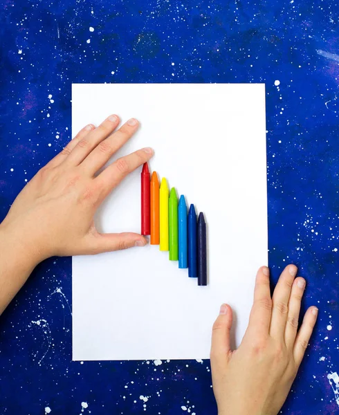 银河蓝色背景上的空白白纸和手持式彩色蜡笔 — 图库照片