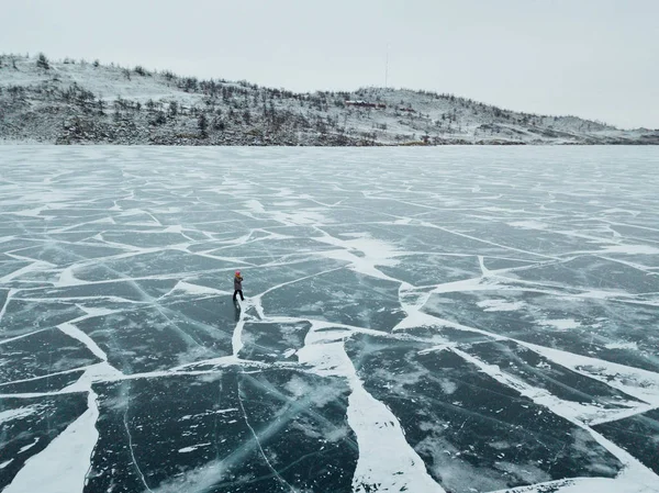 Girl walking on the ice of lake Baikal. The whole surface of the ice is cracked. Ice just got up. — Stock Photo, Image