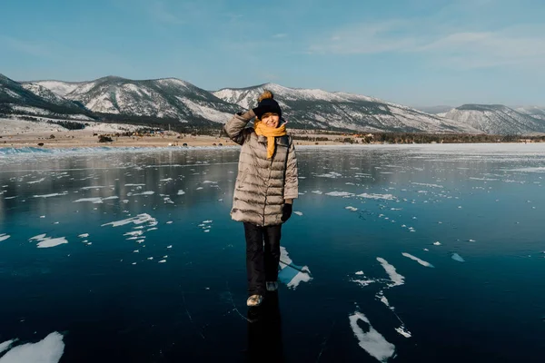 Flickan går på kristallklart Baikal isen. mycket kallt men klart väder. transparent is orsakar panik och glädje — Stockfoto