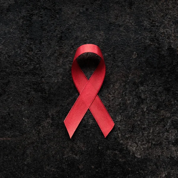 AIDS awareness red ribbon on dark background