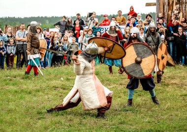 07.22.2017 Rusya, Bryansk. Festivali tarihi askeri imar sevenler için. Vikingler kıyafetlerini giymiş insanlar ve Rus kahramanlar kenarlı silah birbirleriyle mücadele ile silahlı.