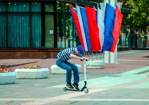 05 14 2019 Rosja, Briańsk. Nastolatek latający w skoku na skuterze na placu miasta. — Zdjęcie stockowe