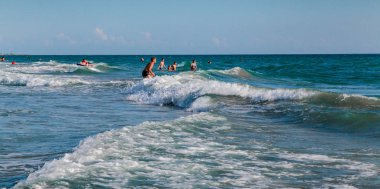 Denizde fırtına. Çocuklar ve yetişkinler büyük dalgalar yakalamak için mutluyuz.