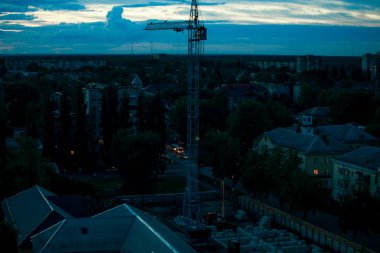 Akşam alacakaranlıkta gökdelendeki vinci izle.