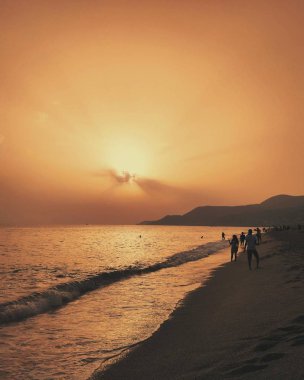Dağları ile deniz günbatımı. Sahilde deniz manzarası.
