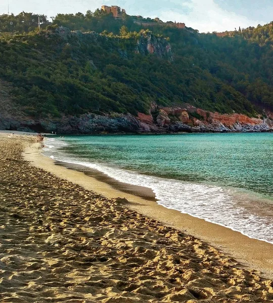 Costa estiva sulla spiaggia. Bellissimo mare blu con montagne e rocce. Isola senza persone . — Foto Stock