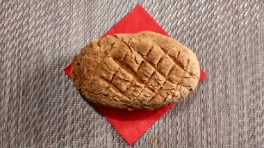 Ev yapımı ekmek kırmızı peçeteyle masanın üzerinde yatan.