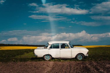 Eski beyaz araba park edilmiş yaz günde sahada. Ukraynalı araba.