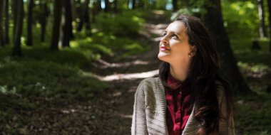 Kadınlar karantina pankartıyla ormanda yalnız vakit geçirmeyi severler. Mutlu kız yukarı bakıyor