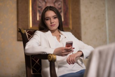 bir iç oturma ve telefonu tutan genç kız