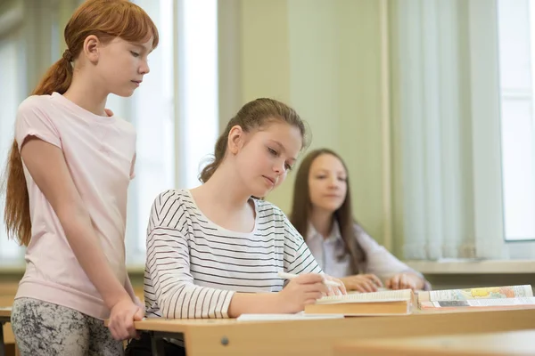 3 estudantes meninas estão sentadas em uma mesa — Fotografia de Stock