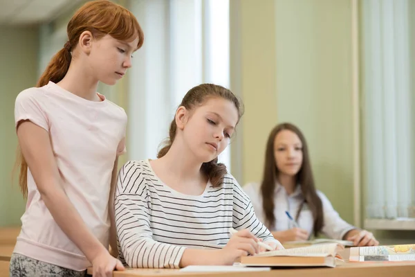 3 estudantes meninas estão sentadas em uma mesa — Fotografia de Stock