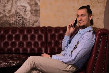 odasında kanepede oturan adam