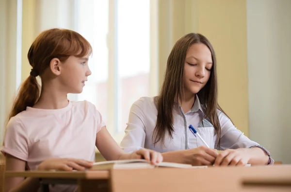 Meninas estudante estão sentados em uma mesa — Fotografia de Stock