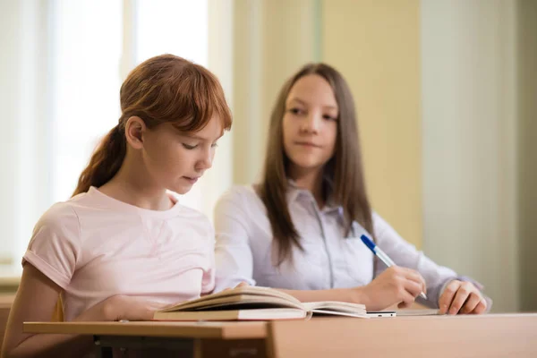 2 uczeń dziewczyny siedzą przy biurku — Zdjęcie stockowe