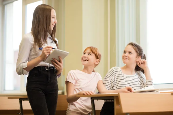 3 uczeń dziewczyny siedzą przy biurku — Zdjęcie stockowe