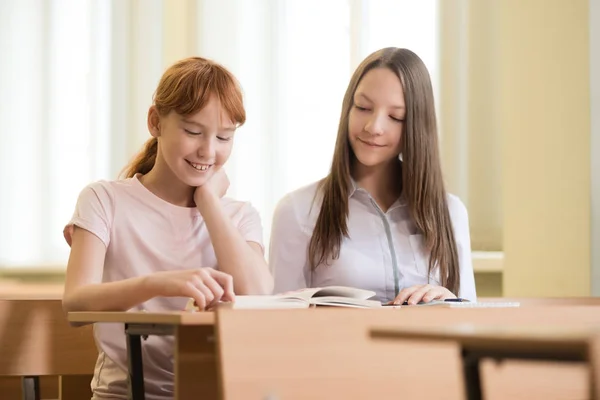2 uczeń dziewczyny siedzą przy biurku — Zdjęcie stockowe