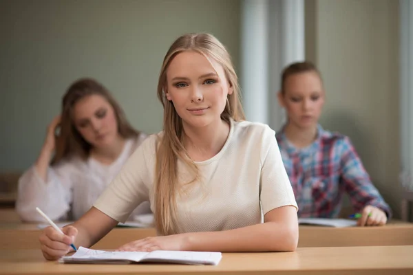 Student meisjes zitten aan een bureau — Stockfoto