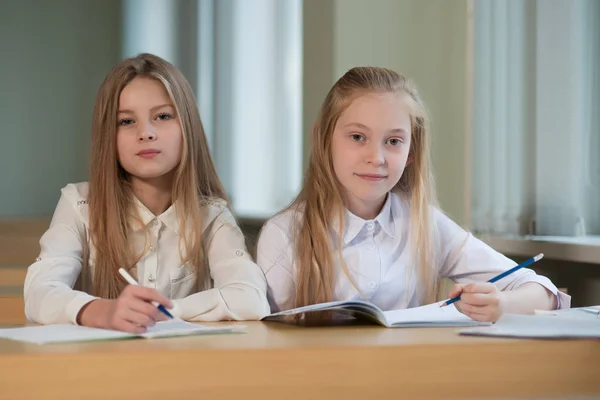 Estudiante niñas están sentados en un escritorio — Foto de Stock