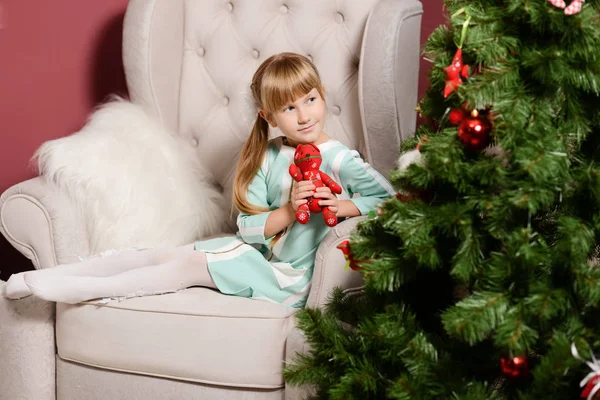 A menina no ao lado da lareira branca, decorar uma árvore de Natal com brinquedos — Fotografia de Stock