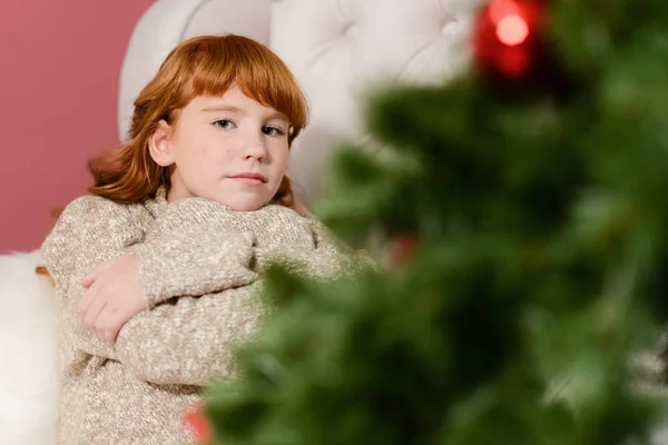 La chica en el lado de la chimenea blanca, decorar un árbol de Navidad con juguetes —  Fotos de Stock