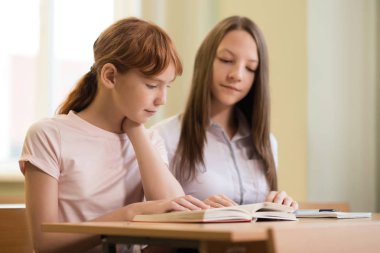 2 öğrenci kız masa başında oturan