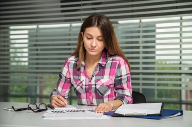 rahat kıyafet oturan gözlüklü genç iş kadını kız tablo bakmak dikkatli belgili tanımlık evrak 