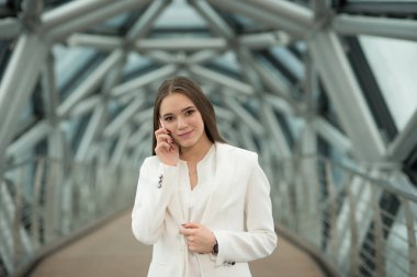 koridorda duran ve telefonu tutan genç bir esmer kız