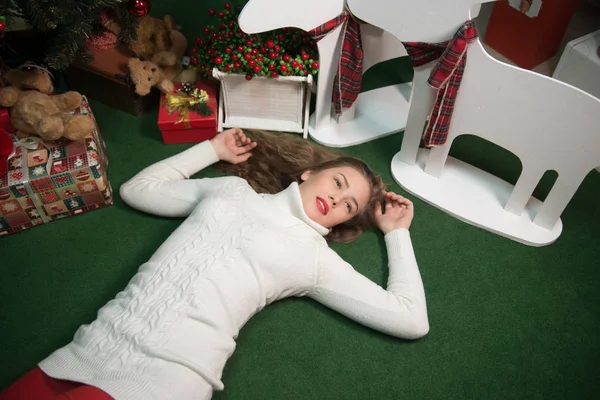 Girls lie next to the Christmas tree with gifts — Stock Photo, Image