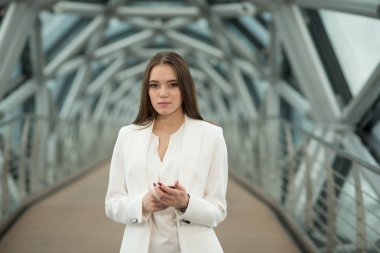 koridorda duran ve telefonu tutan genç bir esmer kız